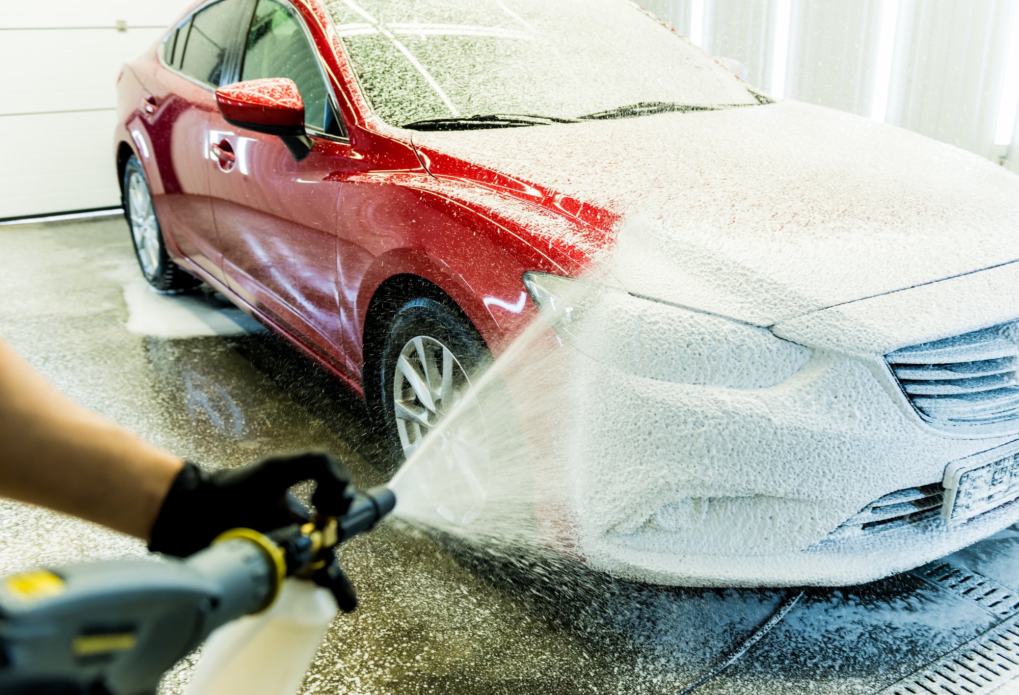 Spraying a car with cleaning foam